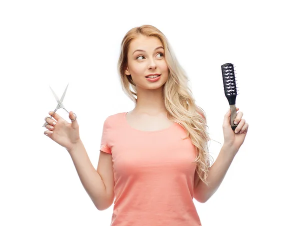 Mujer joven con tijeras y cepillo de pelo —  Fotos de Stock