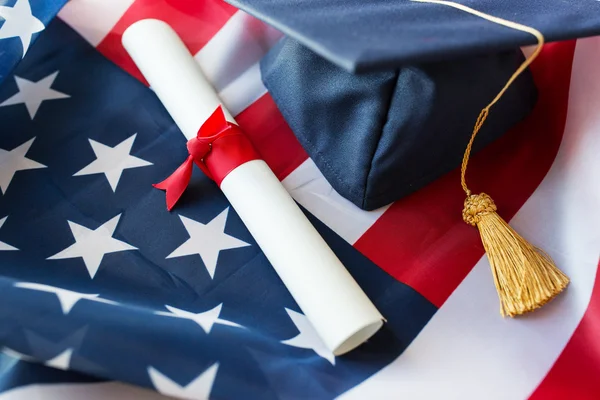 Mortarboard y diploma en bandera americana — Foto de Stock