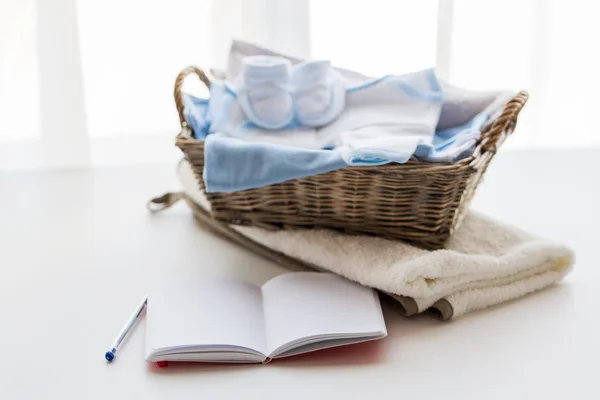 Закрытие детской одежды для новорожденного и ноутбука — стоковое фото