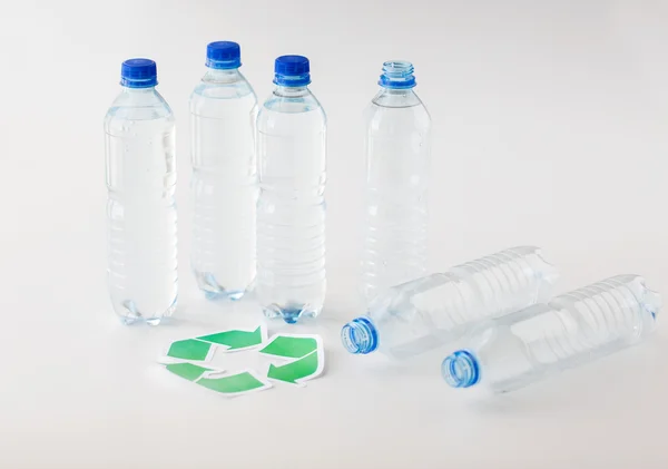 Close up de garrafas de plástico e símbolo de reciclagem — Fotografia de Stock