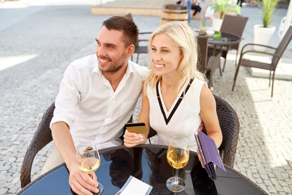 Happy couple with wallet paying bill at restaurant — Stock Photo, Image