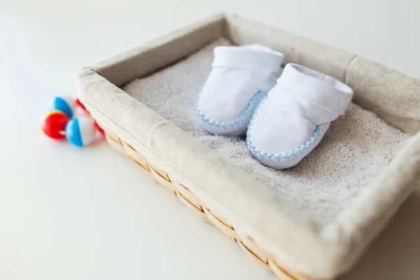 为新生男婴在篮子里的婴儿毛线鞋的特写 — 图库照片