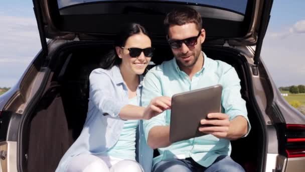 Happy couple met Tablet PC bij hatchback Car trunk — Stockvideo