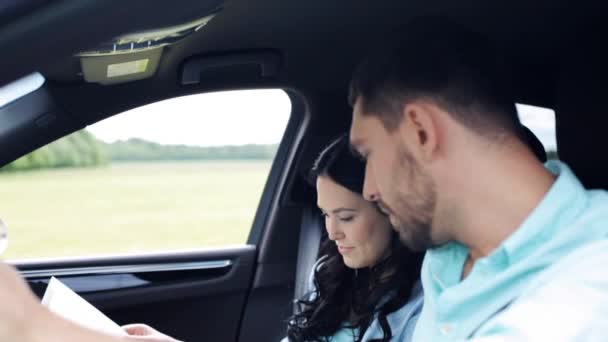 Pareja feliz con mapa discutiendo ruta en coche — Vídeo de stock