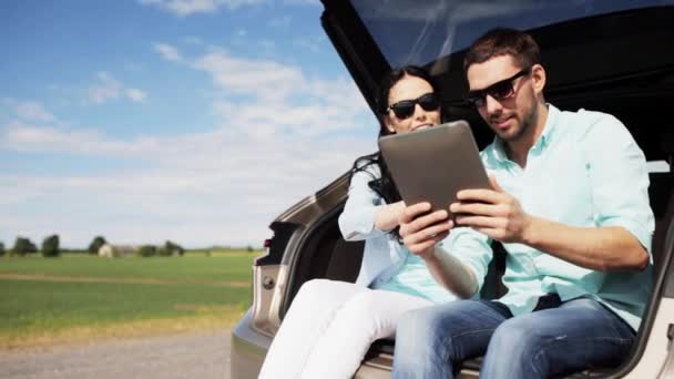 Happy couple with tablet pc at hatchback car trunk — Stock Video