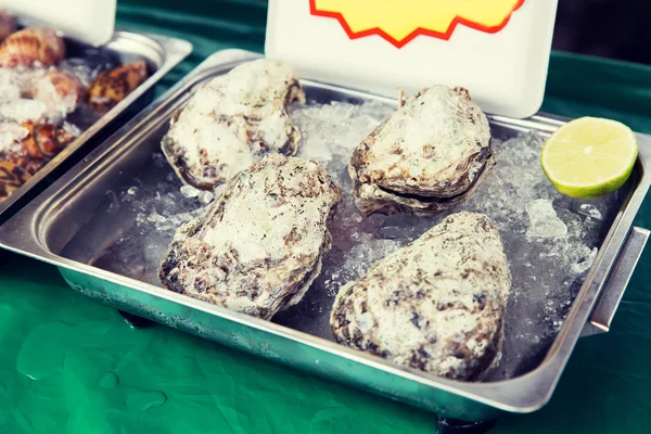 Oysters or seafood on ice at asian street market — Stock Photo, Image