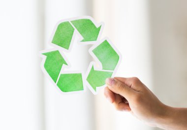 close up of hand holding green recycle symbol clipart