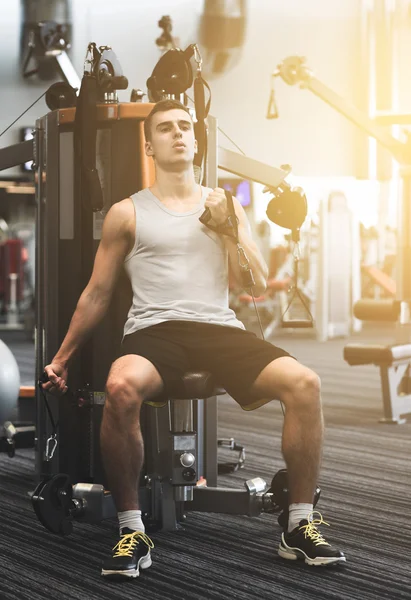 Hombre haciendo ejercicio en la máquina de gimnasio — Foto de Stock