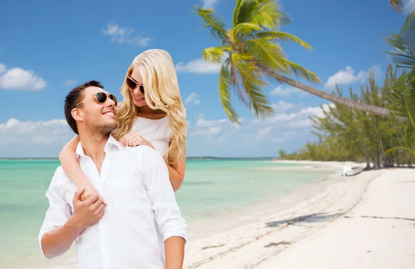 Happy couple in sunglasses over summer beach — Stockfoto