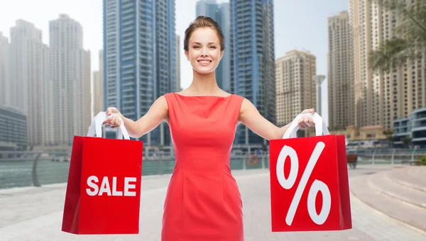 Mujer feliz con bolsas de compras sobre la ciudad de Dubai —  Fotos de Stock