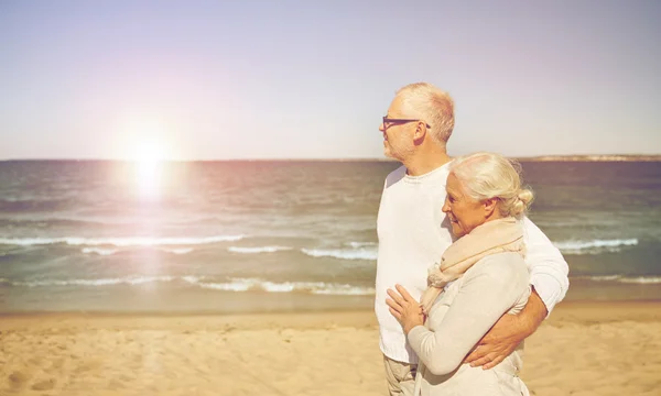 Счастливая пожилая пара, гуляющая по летнему пляжу — стоковое фото