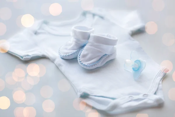 Primer plano de la ropa de los niños del bebé para el recién nacido en la mesa — Foto de Stock