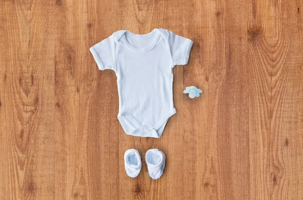 Primer plano de la ropa de los niños del bebé para el recién nacido en la mesa — Foto de Stock