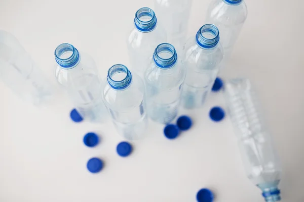 Primo piano di bottiglie d'acqua vuote e tappi sul tavolo — Foto Stock