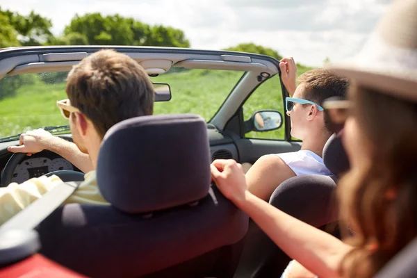 Amigos felizes dirigindo em carro cabriolet — Fotografia de Stock