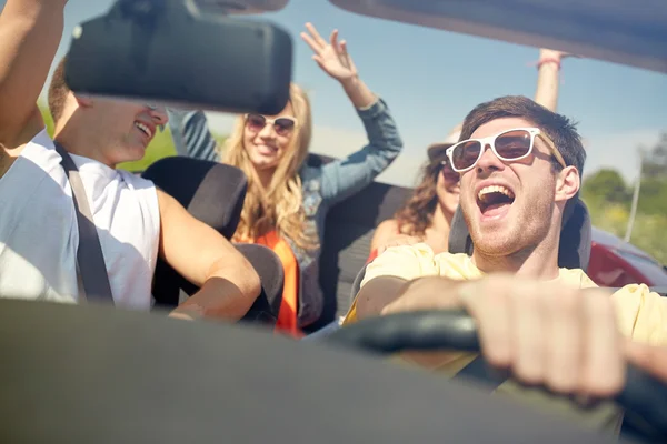 Amigos felizes dirigindo em carro cabriolet — Fotografia de Stock