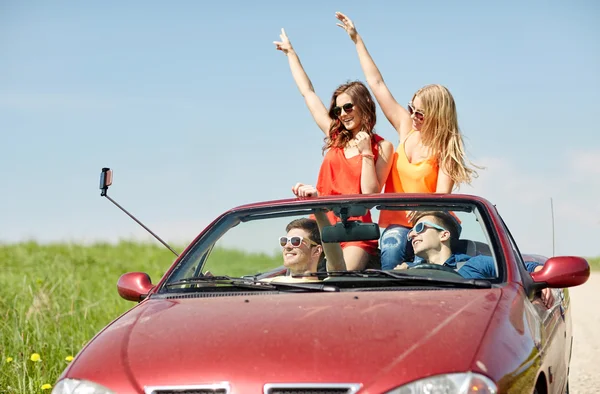 Jazdy w samochodzie cabriolet i biorąc selfie znajomych — Zdjęcie stockowe