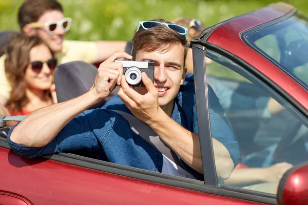 Amigos felices con la conducción de la cámara en coche cabriolet — Foto de Stock