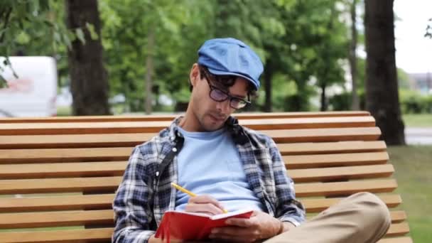 Hombre dibujando cuaderno de bocetos con lápiz en la calle — Vídeos de Stock