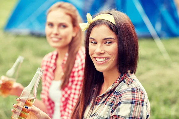Happy young women with tent and drinks at campsite — Stock Photo, Image