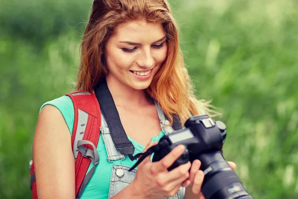 Mulher feliz com mochila e câmera ao ar livre — Fotografia de Stock