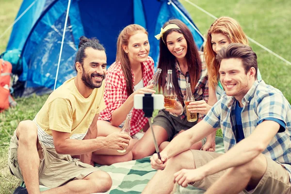 Amigos felizes tirando selfie por smartphone no acampamento — Fotografia de Stock