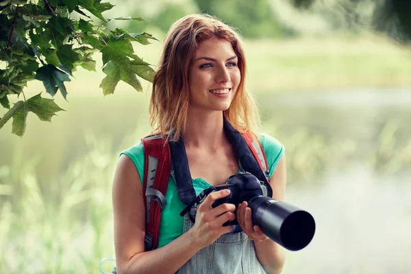 Mujer feliz con mochila y cámara al aire libre —  Fotos de Stock