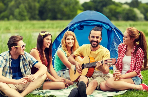 Amici felici con bevande e chitarra al campeggio — Foto Stock
