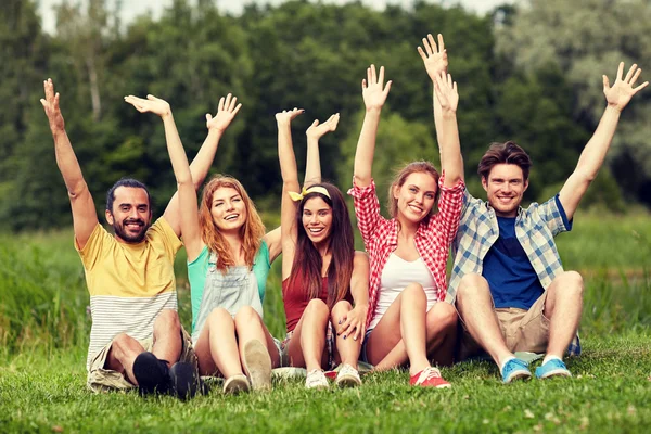 Grupp leende vänner viftande händer utomhus — Stockfoto