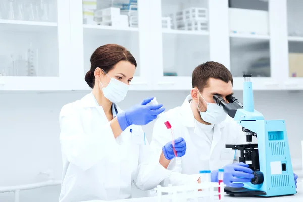 Jóvenes científicos haciendo pruebas o investigaciones en laboratorio —  Fotos de Stock