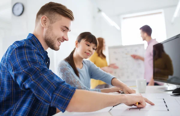 Kreativteam mit Blaupause im Büro — Stockfoto