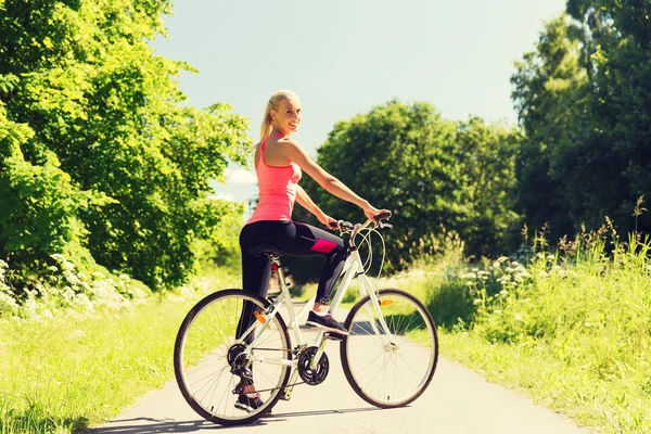Glückliche junge Frau, die im Freien Fahrrad fährt — Stockfoto