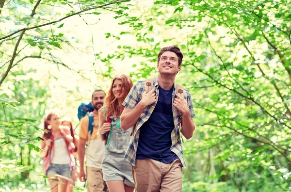 Groep lachende vrienden met rugzakken wandelen — Stockfoto