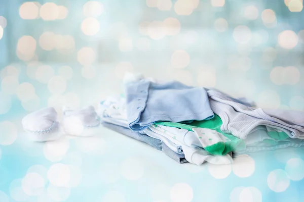 Primer plano de la ropa de los niños del bebé para el recién nacido en la mesa — Foto de Stock