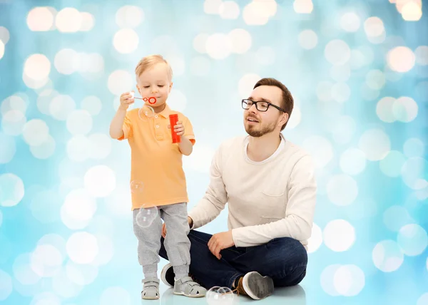 Vader en zoon blazen van zeepbellen en plezier — Stockfoto