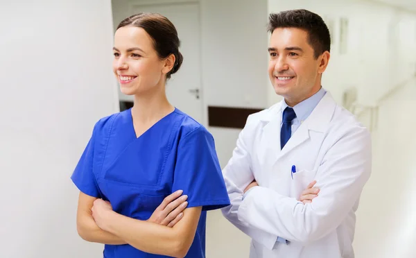 Médecin souriant en manteau blanc et infirmière à l'hôpital — Photo