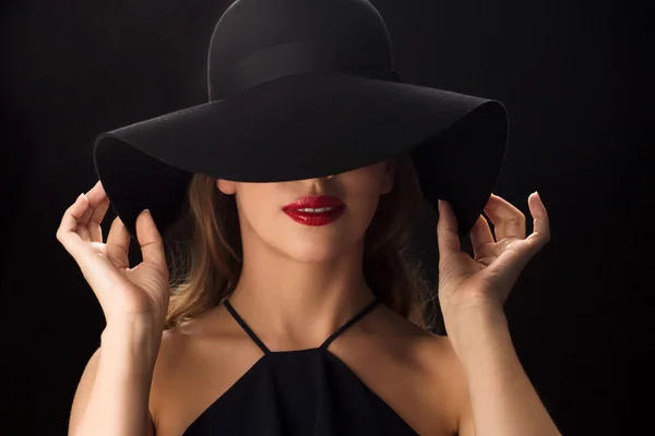 Beautiful woman in black hat over dark background — Stock Photo, Image