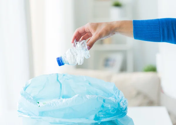 Κοντινό πλάνο της χέρι και χρησιμοποιημένα μπουκάλια σε σακούλα σκουπιδιών — Φωτογραφία Αρχείου