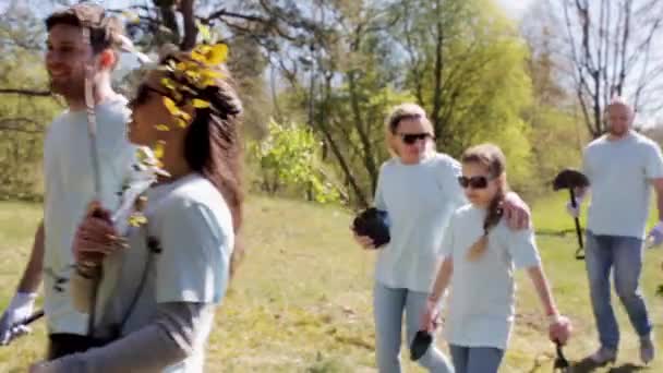 Group of volunteers with tree seedlings in park — Stock Video