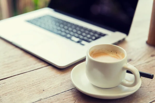 Primo piano del computer portatile e della tazza di caffè sul tavolo dell'ufficio — Foto Stock