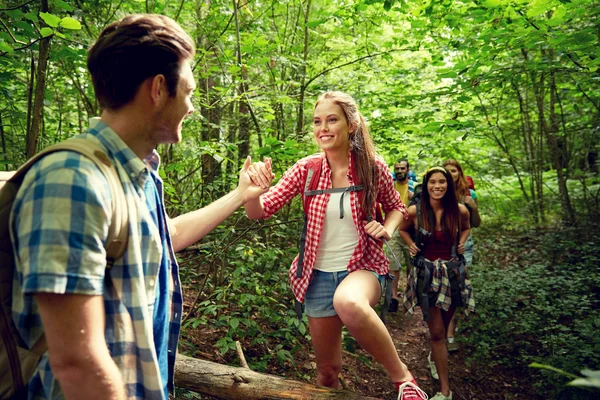 Gruppe lächelnder Freunde mit Rucksäcken beim Wandern — Stockfoto