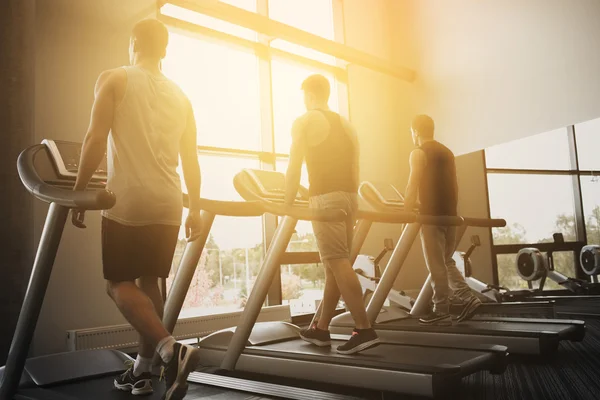 Männer trainieren auf Laufband im Fitnessstudio — Stockfoto