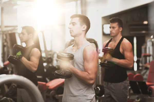 Männergruppe mit Kurzhanteln im Fitnessstudio — Stockfoto
