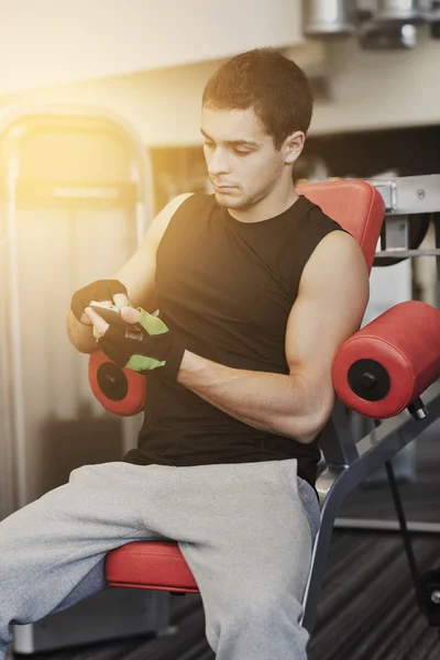 Young man with smartphone in gym — Stock Photo, Image