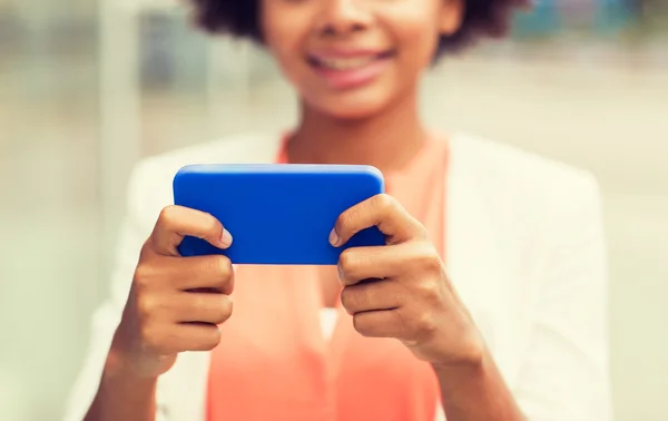 Primer plano de la mujer africana con smartphone en la ciudad Imagen de archivo