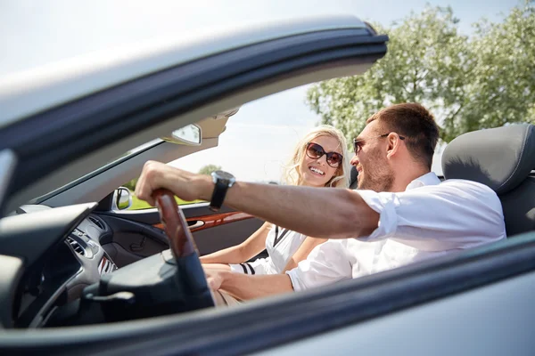 Feliz hombre y mujer conduciendo en coche cabriolet — Foto de Stock