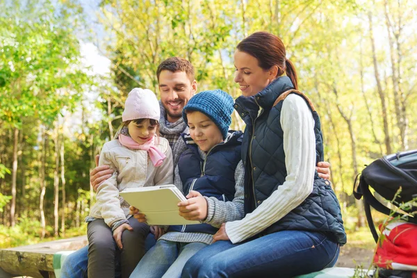 Happy family with tablet pc and backpacks at camp — Stock Photo, Image