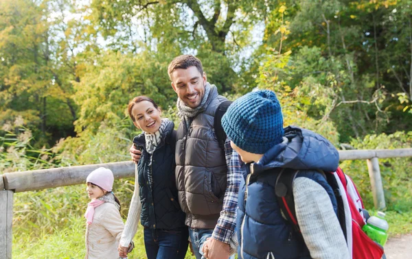 Lycklig familj med ryggsäckar vandring i skogen — Stockfoto