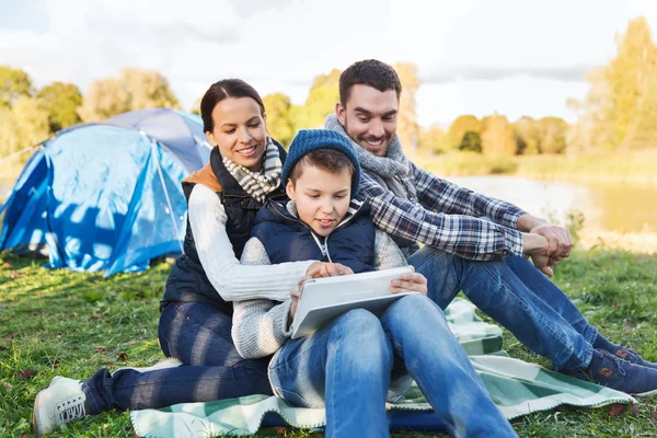 Família feliz com tablet pc e barraca no local do acampamento — Fotografia de Stock