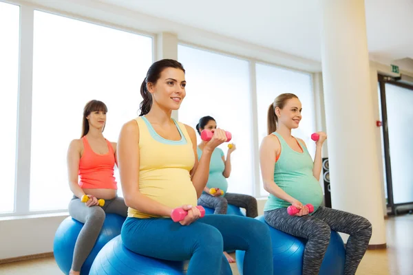 Mujeres embarazadas felices haciendo ejercicio en fitball en el gimnasio —  Fotos de Stock